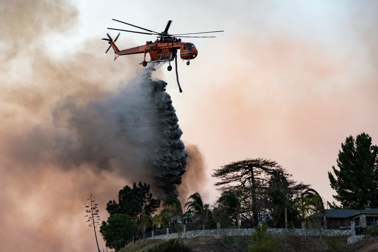 Un helicóptero de los bomberos intenta sofocar el fuego que se desplaza hacia Los Ángeles. El alcalde de la ciudad, Eric Garcetti, declaró el estado de emergencia.