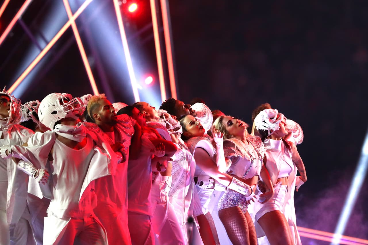 Lady Gaga dio un show en el que bajó desde el techo colgada, dando incluso vueltas sin dejar de cantar. Tras su llegada aérea, le imprimió mucha energía al baile, con una presentación panorámica con coreografía de luces, con referentes al fútbol americano y con una temática dirigida hacia la unidad nacional.