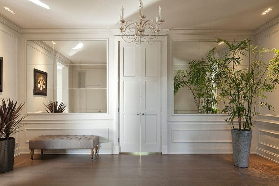 El recibidor cubierto con boiserie blanca.