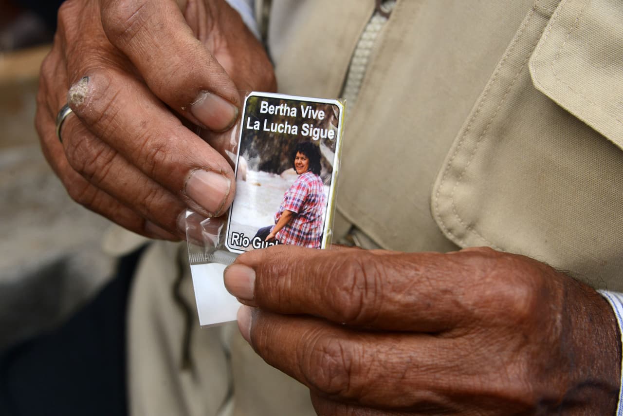 Un hombre sostiene una leyenda en honor de la activista durante el funeral