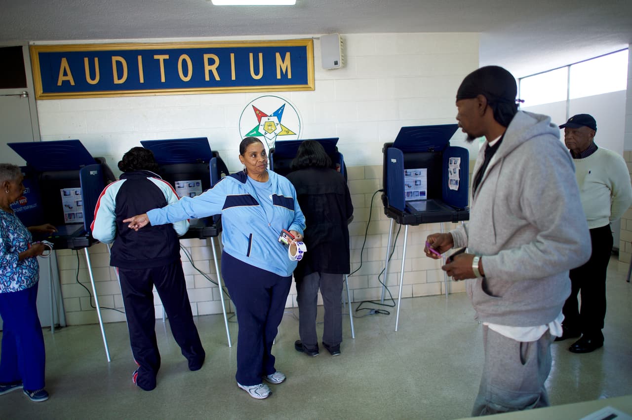 Una funcionaria de la mesa de votación ubicada en el Prince Hall Masonic Lodge de Columbia conduce a un elector. (Foto por Mark Makela).
