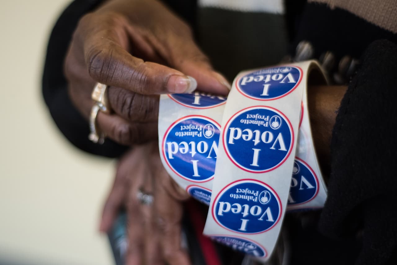 Un trabajador alista las calcomanias para entregar al final de la votación a quienes participen en la primaria demócrata de este sábado en Carolina del Sur. (Foto por Sean Rayford).