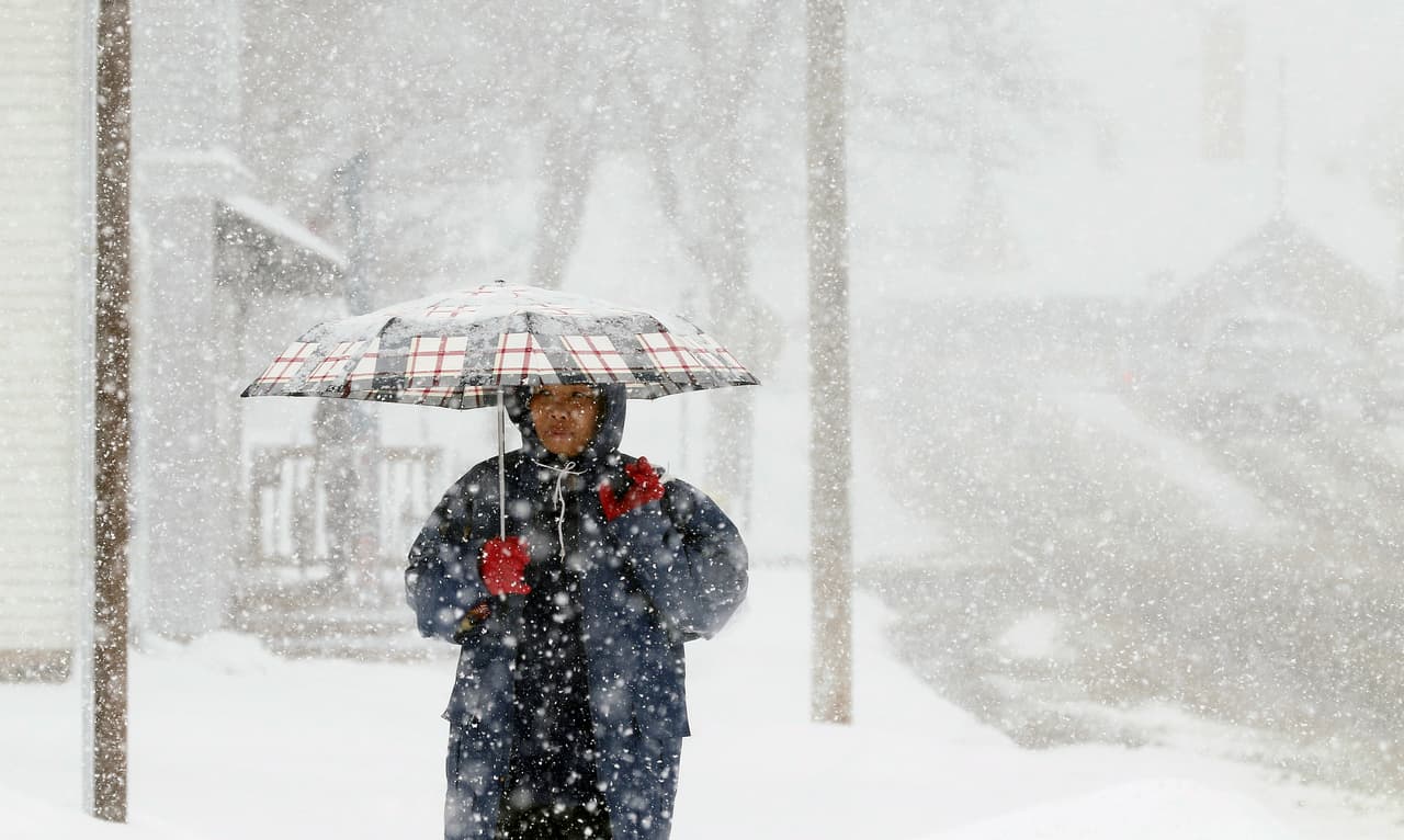 Esta mujer camina de su trabajo a su casa en West Bend, Wisconsin, donde este lunes cayó una fuerte nevada