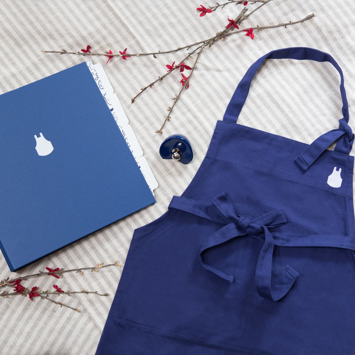 "Cocinar sano como un profesional", es la idea detrás de los alimentos, productos y recetas de Blue Apron. Uno de sus kits clásicos es el Blue Apron Set ($39.99) que incluye un mandil, un recetario y una carpeta para que el chef de casa archive sus recetas y notas.