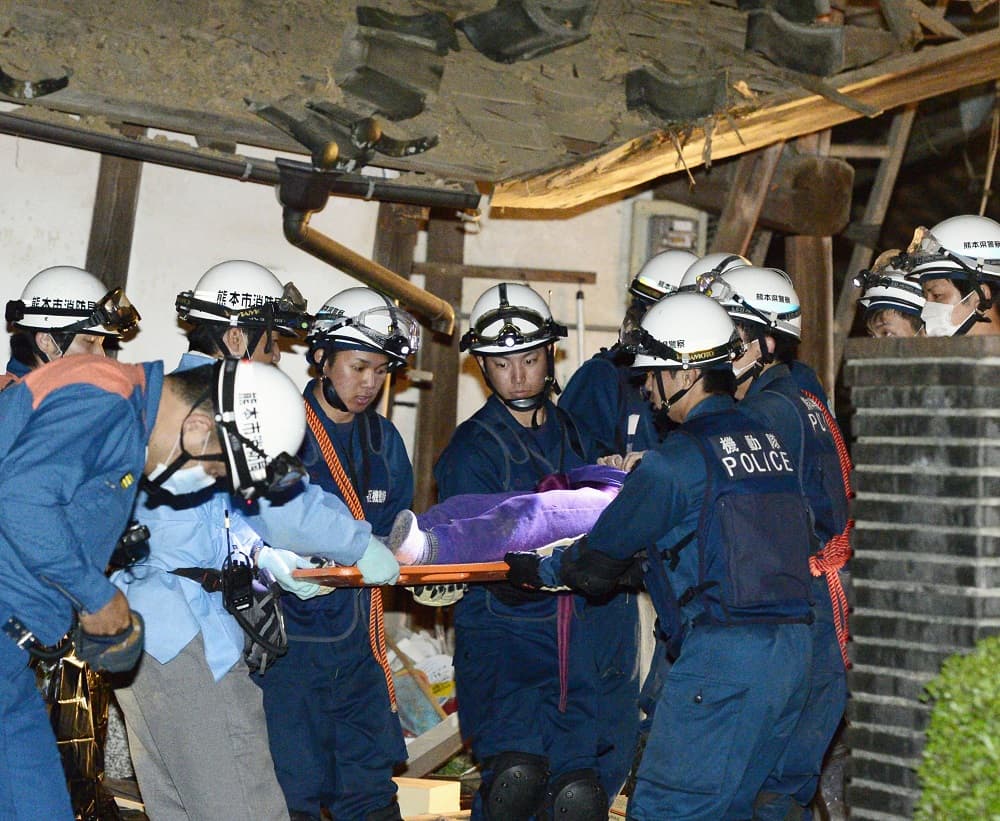 Varios resctatistas consiguen liberar a una persona de entre los escombros por el sismo