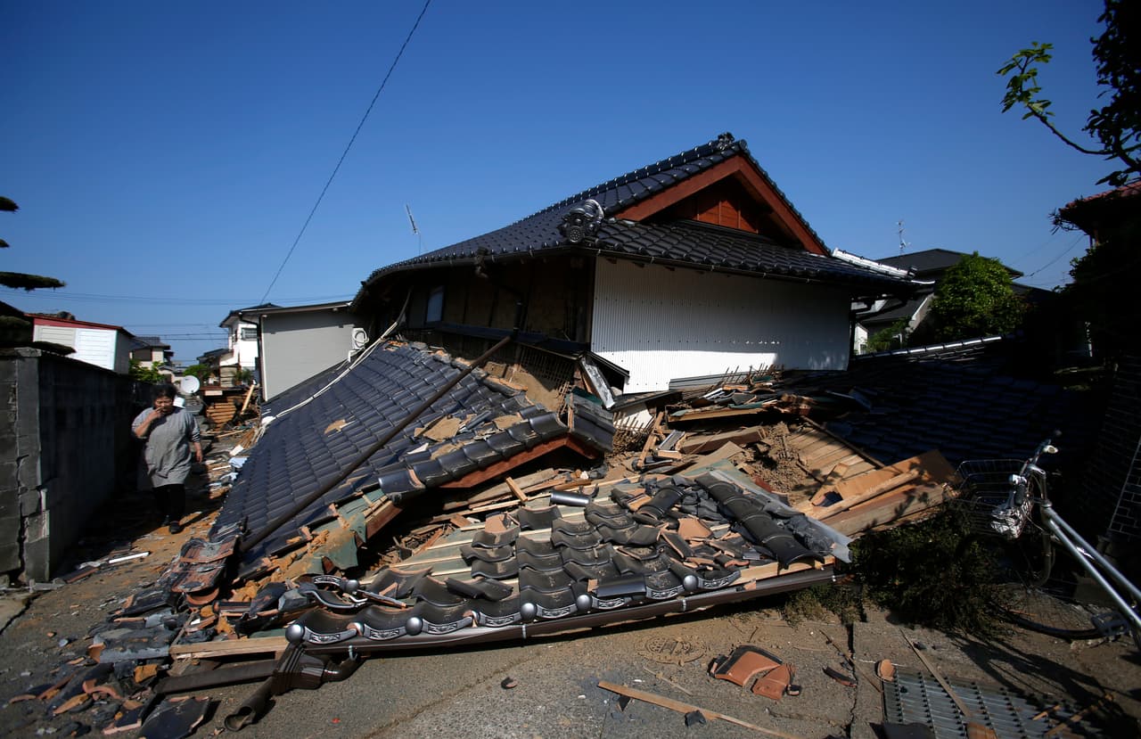 Un residente de Mashiki camina junto a los escombros de una casa completamente destruida