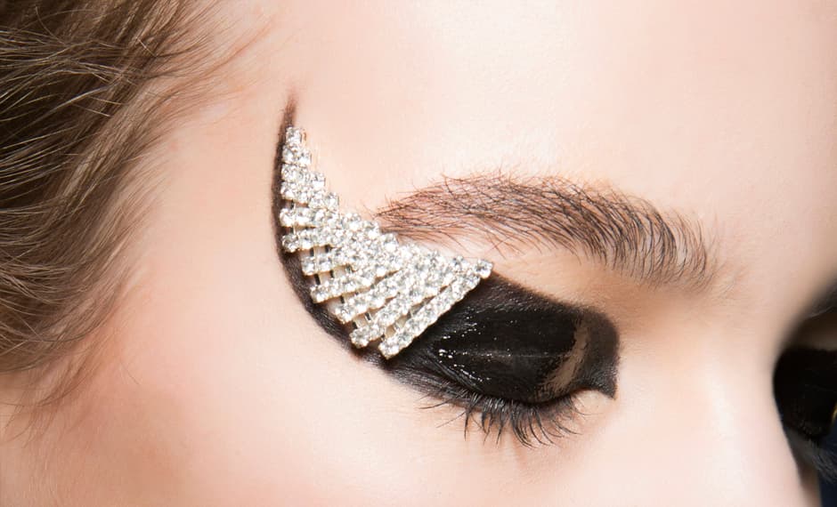 En el desfile del diseñador
<a href="http://www.anthonyvaccarello.com/">Anthony Vaccarello</a> le dieron al maquillaje de ojos un toque lujoso y único. El maquillista
<a href="https://www.instagram.com/tompecheux/?hl=en">Tom Pecheux</a> le dio un toque punk a los ojos y aplicó unas pequeñas piezas de cristal en el maquillaje. Si no te anima a llevar esos brillos imita el delineado estilo cate eyes y satúralo de delineador negro. Otra opción es aplicar glitter en tono plateado para imitar este efecto.
<br>