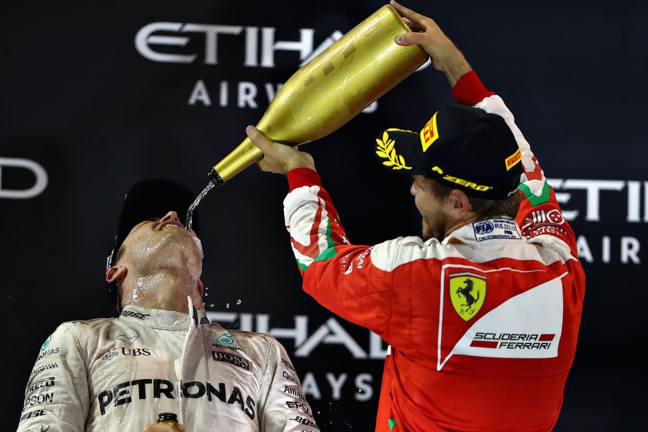 ABU DHABI, UNITED ARAB EMIRATES - NOVEMBER 27: Nico Rosberg of Germany and Mercedes GP celebrates finishing second on the podium and winning the World Drivers Championship with third place finisher Sebastian Vettel of Germany and Ferrari during the Abu Dhabi Formula One Grand Prix at Yas Marina Circuit on November 27, 2016 in Abu Dhabi, United Arab Emirates. (Photo by Clive Mason/Getty Images)