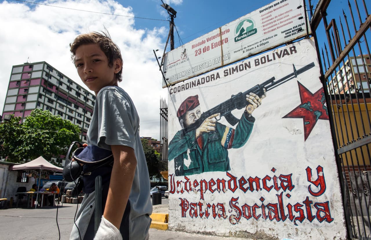 Un niño pasa frente a un mural de Hugo Chávez en el barrio 23 de Enero de Caracas.