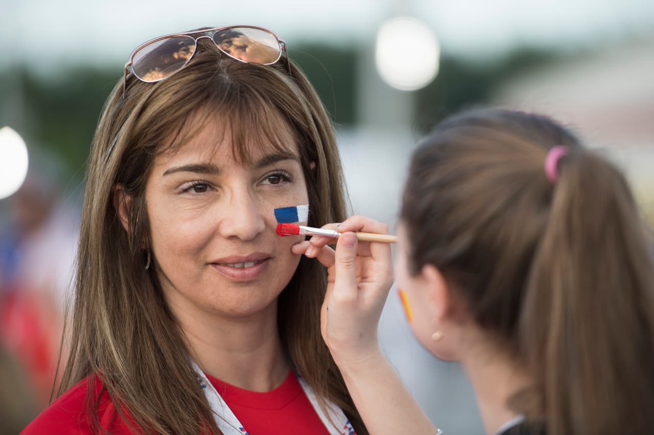 A las afueras del estadio varias personas se dedicaron a pintar las banderas de los equipos protagonistas del partido.