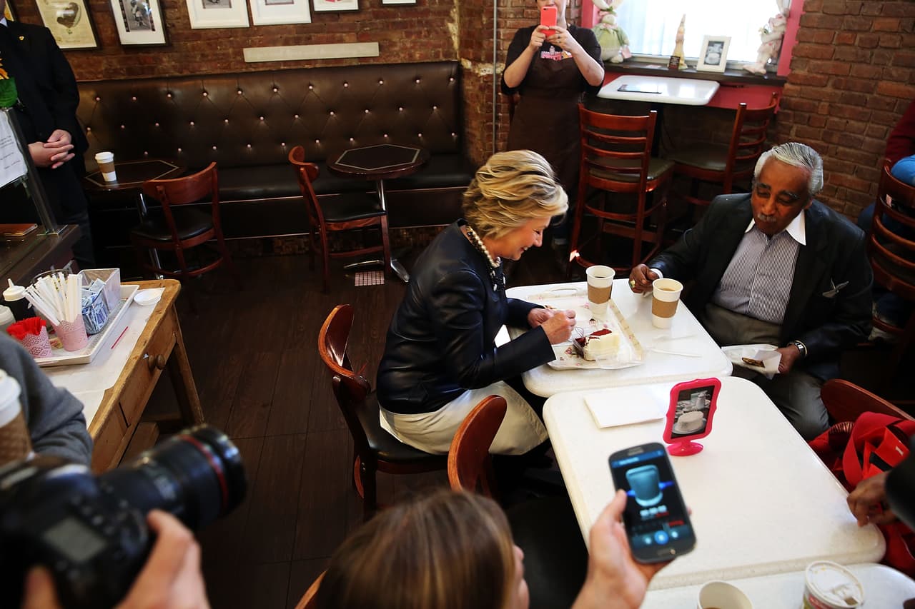 Bajo la atenta mirada de periodistas, Hillary Clinton "rompió" la dieta compartiendo un pedazo de pastel con el congresista Charles Rangel.