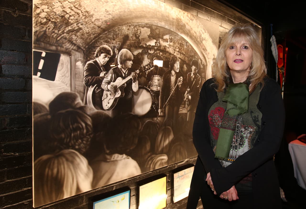La artista plástica Shannon MacDonald junto a una de las tantas piezas que exhibe en The Cavern y que capturan momentos clave en la historia del club.
