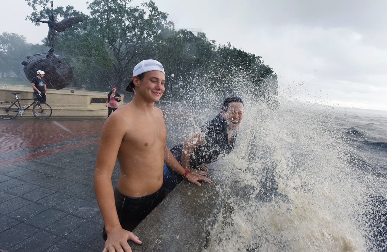 Connor Sidman y su madre Peggy Sidman son golpeados por el oleaje en el Memorial Park, en Jacksonville, Florida. Hermine se degradó a tormenta tropical después de tocar tierra pero el Centro Nacional de Huracanes de Estados Unidos dice que los vientos están aumentando a lo largo de la costa sureste y lluvias torrenciales continúan.