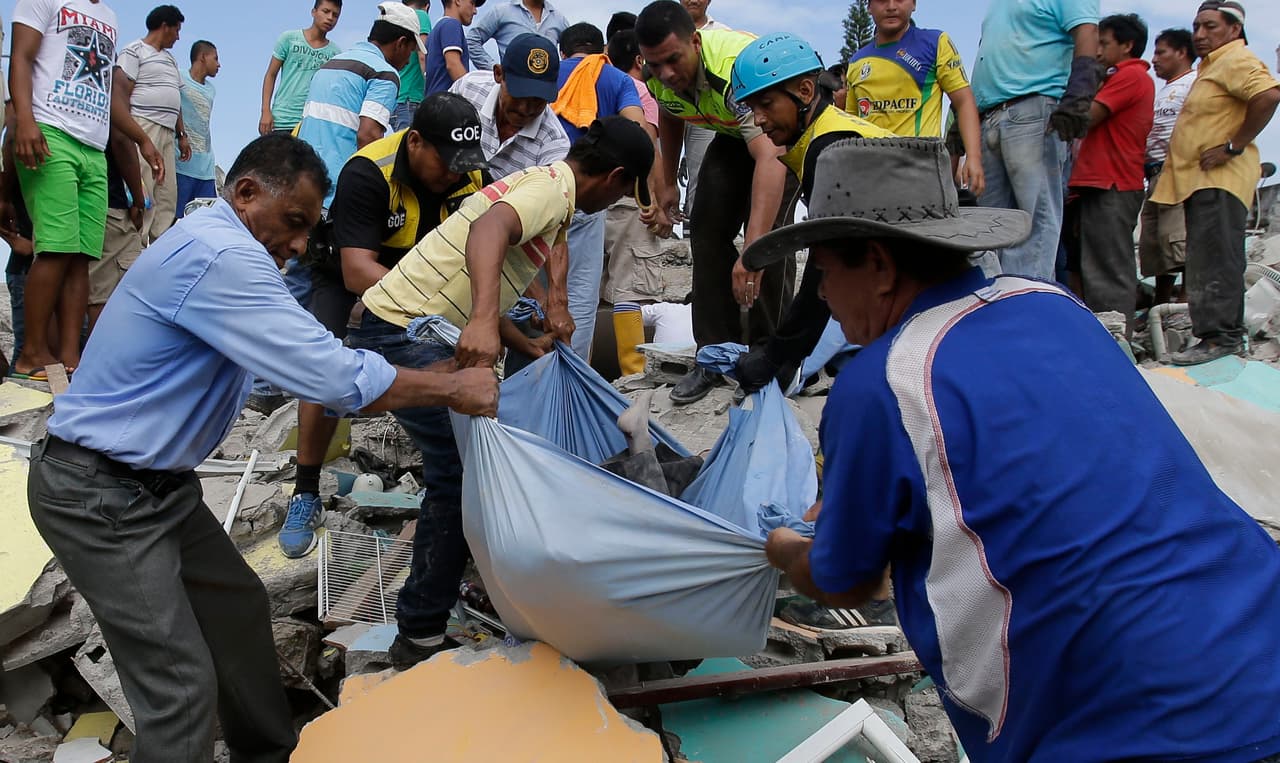 Voluntarios contribuyen a la tarea de sacar los cuerpos atrapados entre las ruinas de las viviendas