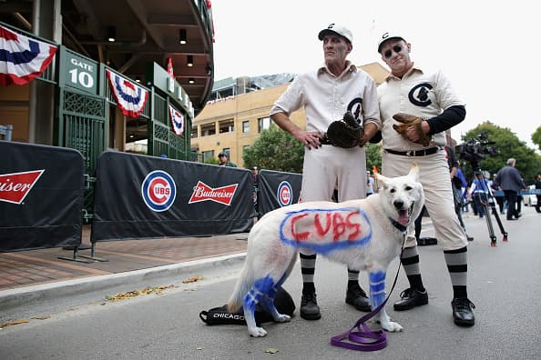 CHICAGO, IL - OCTOBER 15: Chicago Cubs fans pose with a dog outside of Wrigley Field prior to game one of the National League Championship Series between the Chicago Cubs and the Los Angeles Dodgers on October 15, 2016 in Chicago, Illinois. (Photo by Jamie Squire/Getty Images)