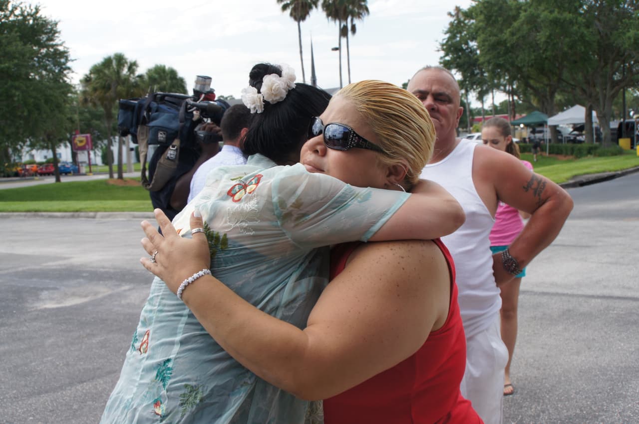 Jessica Velazquez abraza a una seguidora de Christina Grimmie, ambas lloran por la muerte de la cantante.