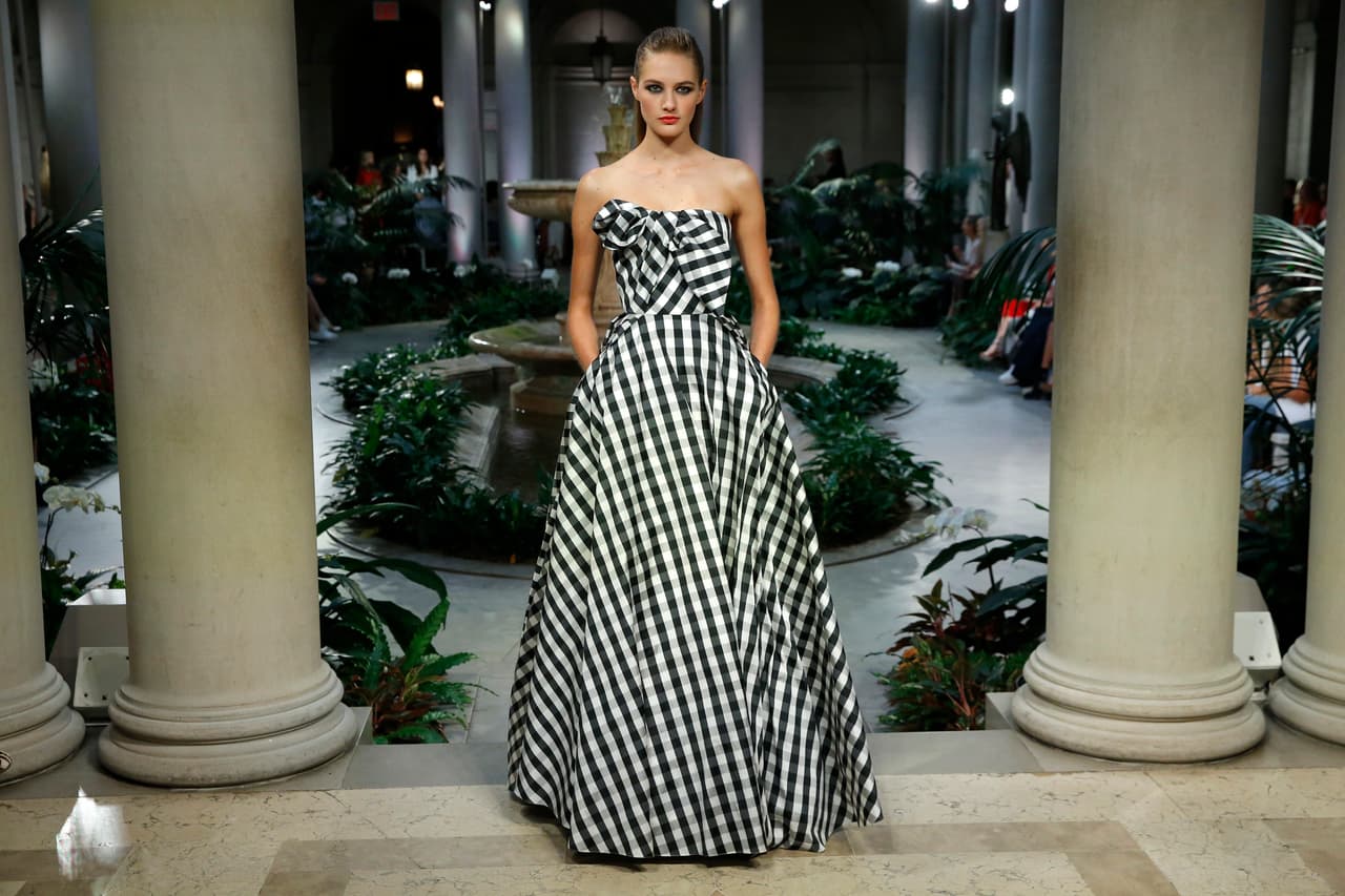 Frase 8: Carolina Herrera siempre ha proclamado que "al menos una vez en su vida una mujer debe tener la experiencia de vestir un verdadero y sustuoso vestido de fiesta". Por eso, en sus colecciones siempre hay trajes largos muy exquisitos y formales que elevan a las mujeres a otra dimensión de la elegancia como este de cuadros blancos y negros con complejo drapeado en el top.