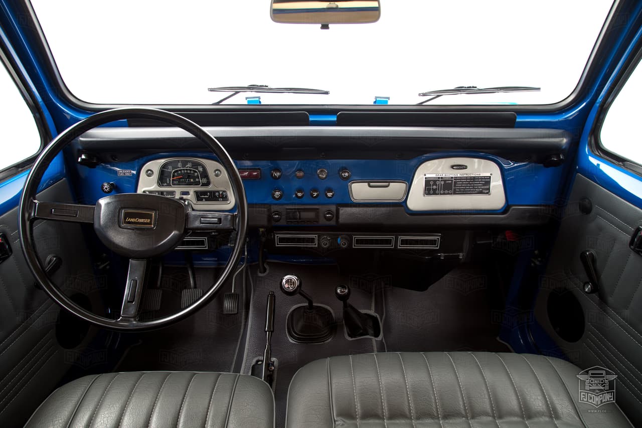 El tablero de instrumentos y controles de esta FJ40 de 1980 es simple y funcional. La única modificación significativa que hizo la gente de The FJ Company fue la de incluir un
<b>sistema de sonido premium</b>, con Bluetooth incorporado, pero lo hacen de una forma tan discreta que no desentona con la originalidad del resto de la cabina. La palanca más pequeña a la derecha de la palanca de la transmisión manual srive para seleccionar los
<b>distintos modos de tracción</b>; Tracción trasera (H2), tracción en la 4 ruedas alta (H4) y tracción en las 4 ruedas baja (L4) o 'mocha' como le dicen en Venezuela.