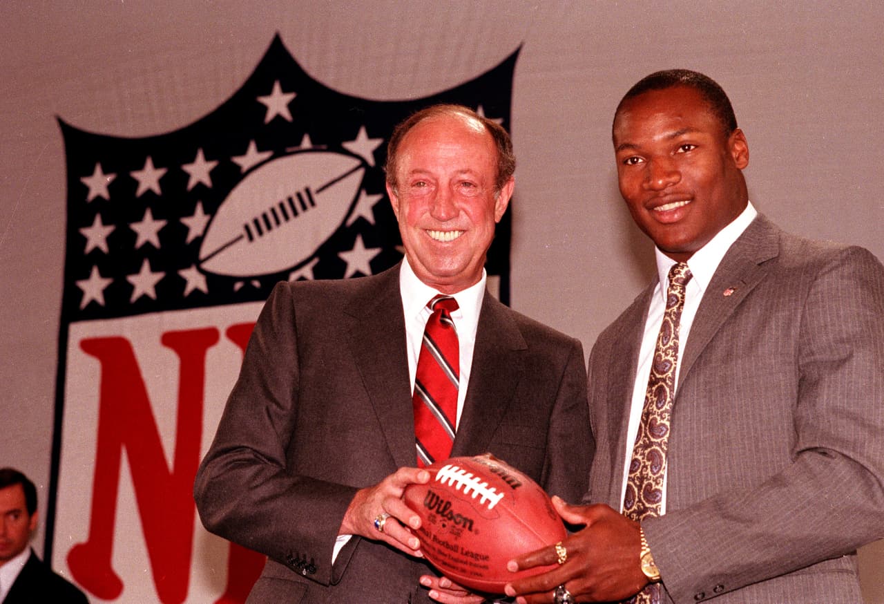 1986 — BO JACKSON
<b>Tampa Bay Buccaneers</b> | RB Auburn
<br>El comisionado de la NFL, Pete Rozelle, junto al corredor de Auburn, Bo Jackson, luego de ser elegido como primera selección global del Draft por Tampa Bay el martes 29 de abril de 1986 en Nueva York. Jackson se negó a firmar con los Bucs, siguió jugando béisbol, y al año siguiente se unió a los Raiders. (Foto AP / Richard Drew)