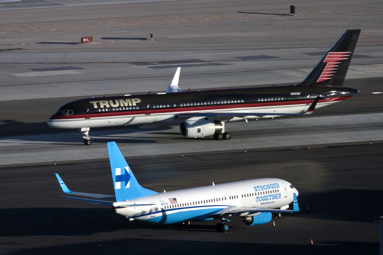 TOPSHOT - Republican presidential nominee Donald Trump's plane (TOP) passes Democratic presidential nominee Hillary Clinton's campaign plane at McCarran International Airport on October 18, 2016 in Las Vegas, Nevada, on the eve of the two candidates' third and final US presidential debate. / AFP / Brendan Smialowski (Photo credit should read BRENDAN SMIALOWSKI/AFP/Getty Images)