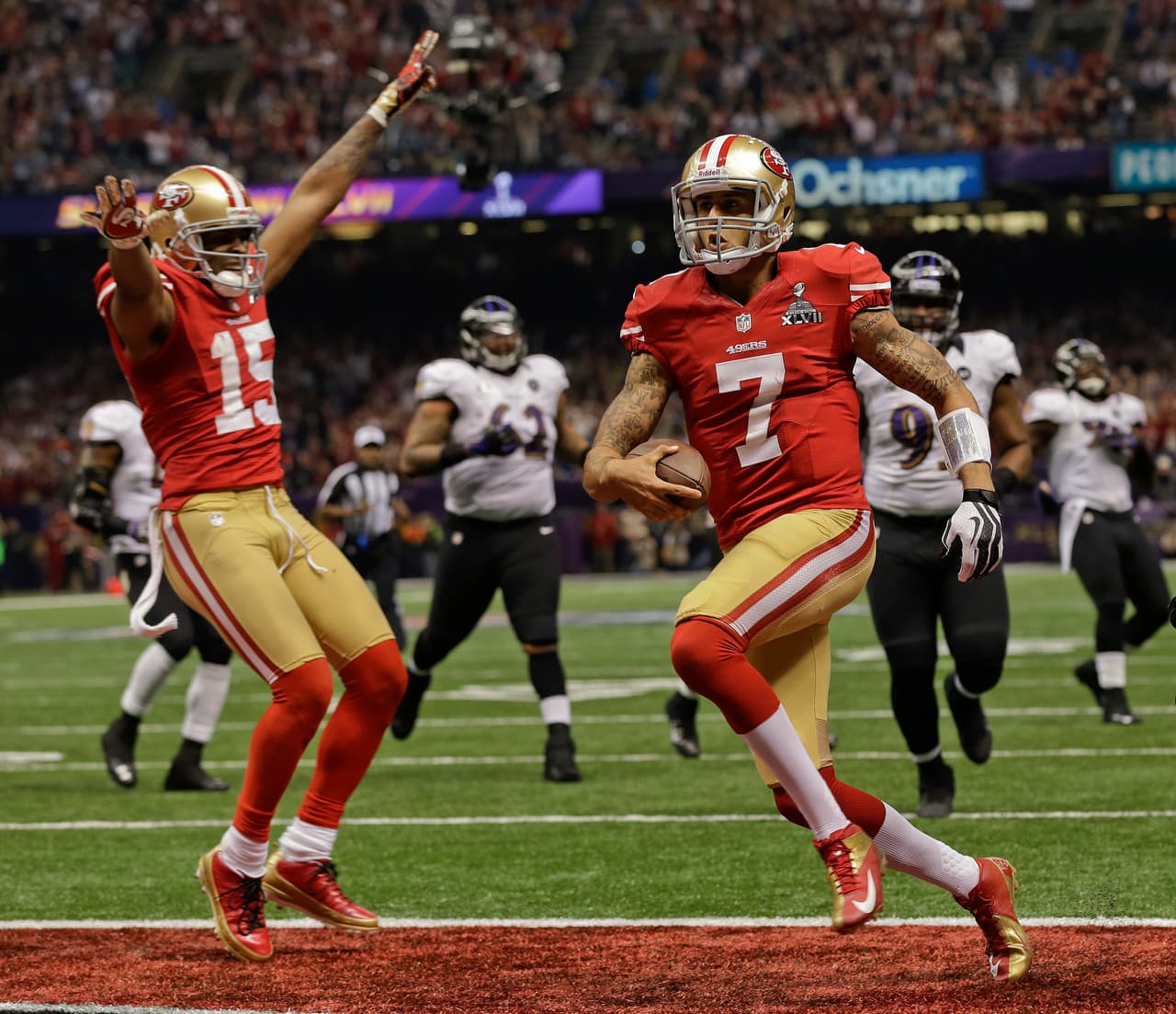 San Francisco 49ers quarterback Colin Kaepernick (7) crosses the goal line for a touchdown as wide receiver Michael Crabtree (15) reacts in the fourth quarter of the NFL Super Bowl XLVII football game against the Baltimore Ravens, Sunday, Feb. 3, 2013, in New Orleans. (AP Photo/Dave Martin)
