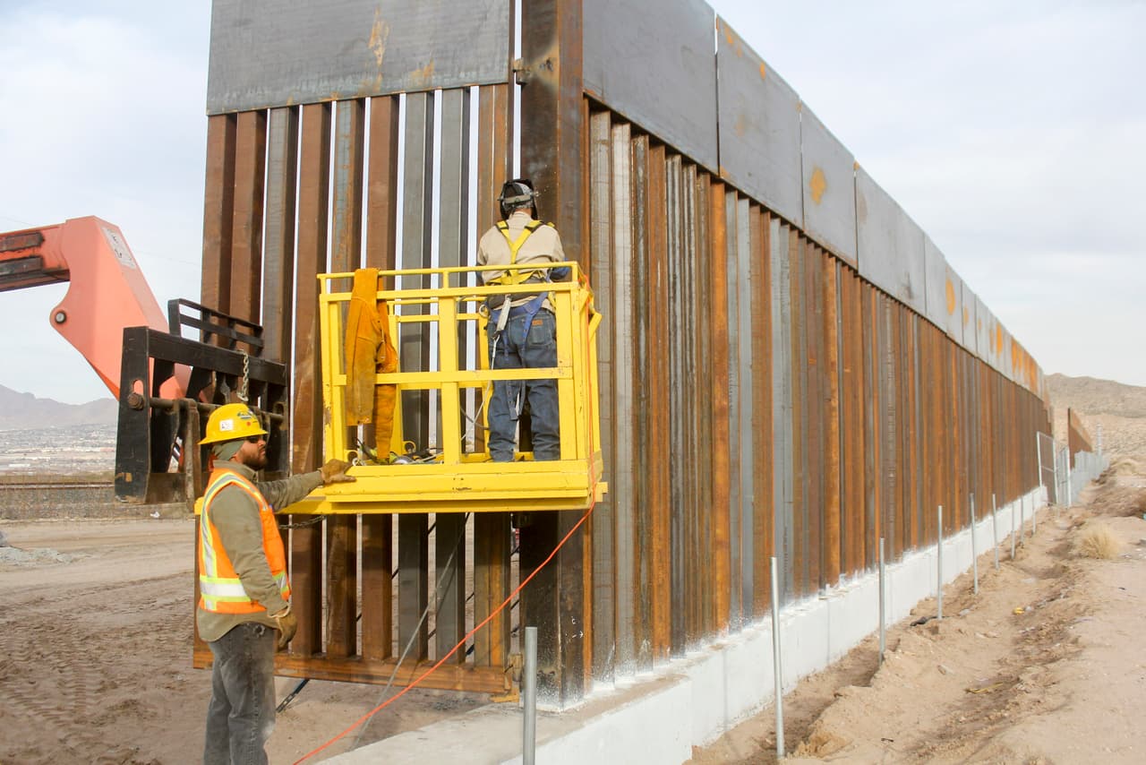 Trabajadores alistando detalles en el muro entre Estados Unidos y Ciudad Juárez, a la altura del poblado Sunland, Nuevo México. (Archivo)