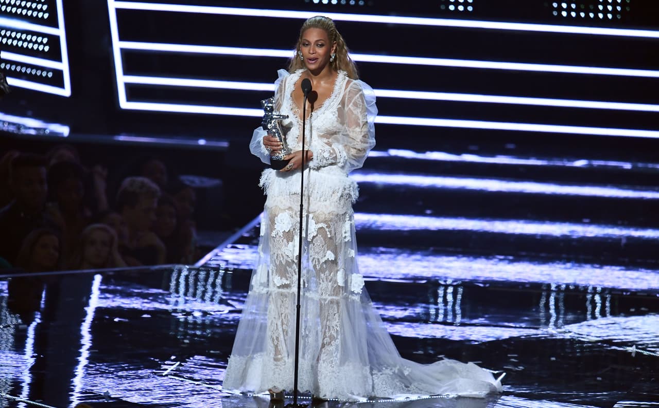 Y para declararse definitivamente como la reina de la noche, la autora de 'Lemonade' se cambió por tercera vez usando un vestido
<i>off white </i>de transparente organza y apliques para recibir el premio a Mejor Video del Año por su trabajo 'Formation', que generó mucho revuelo en su lanzamiento. La cantante recibió de sus 11 nominaciones, 7 premios.