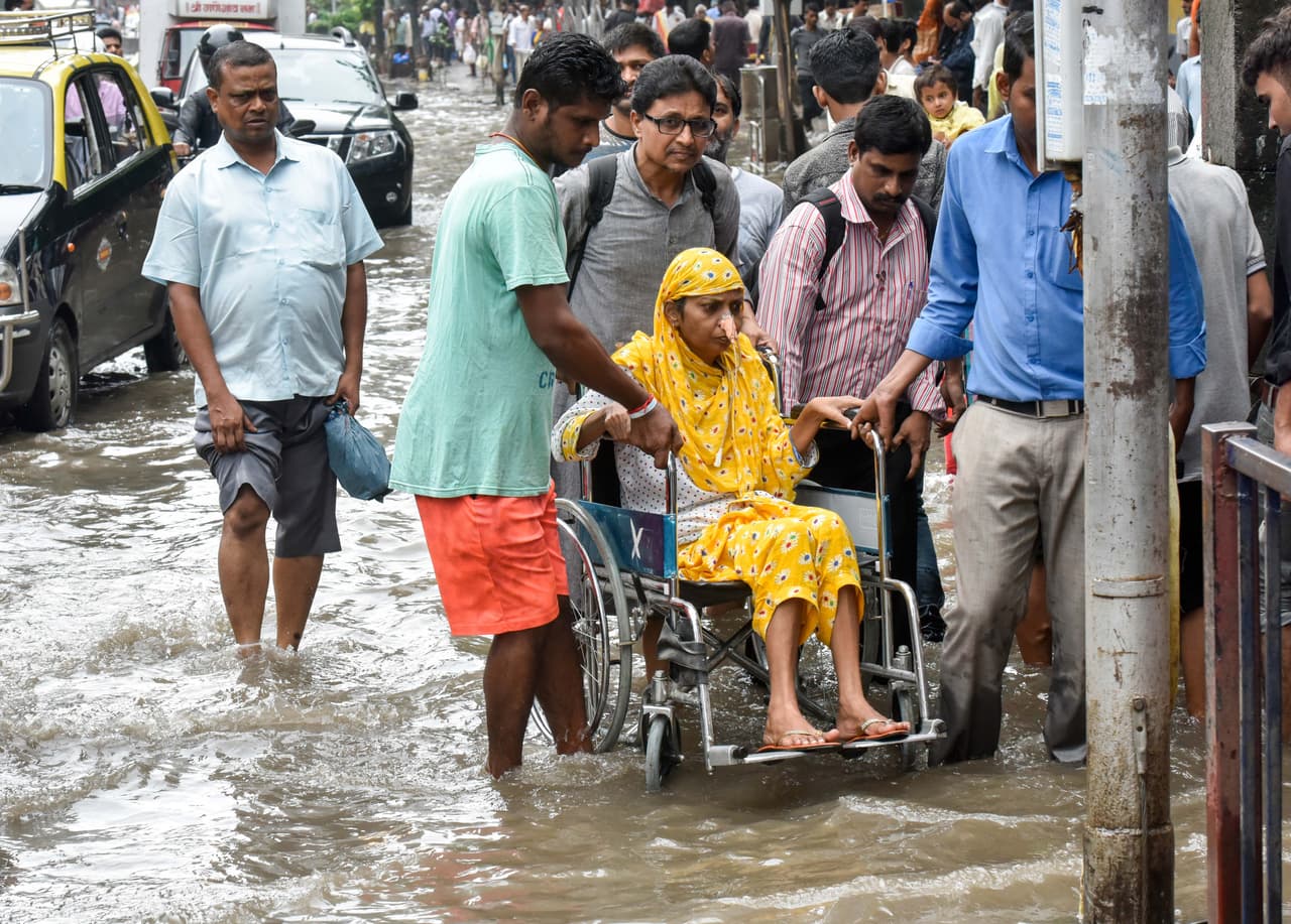 Un enfermo es asistido en una calle inundada de Mumbai. En Nepal, 150 personas murieron y 90,000 hogares quedaron destruidos, en lo que la ONU calificó como el peor episodio de este tipo en una década.