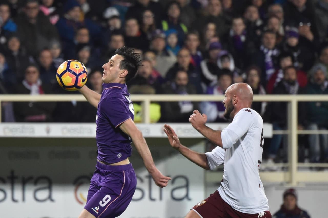 Arlin Ajeti (Torino) presiona al delantero Nikola Kalinic (Fiorentina), quien toma posesión de la pelota.