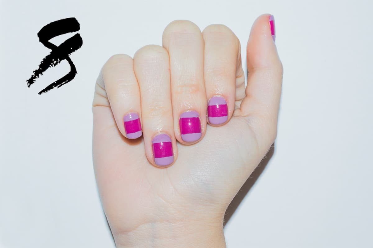 Da dos capas de un tono morado obscuro, deja secar. Coloca un trozo de cinta mágica en el centro de la uña, dejando descubierta la punta y lúnula. Pinta con un tono diferente de morado estas zonas. Cuando seque, despega la cinta con cuidado.