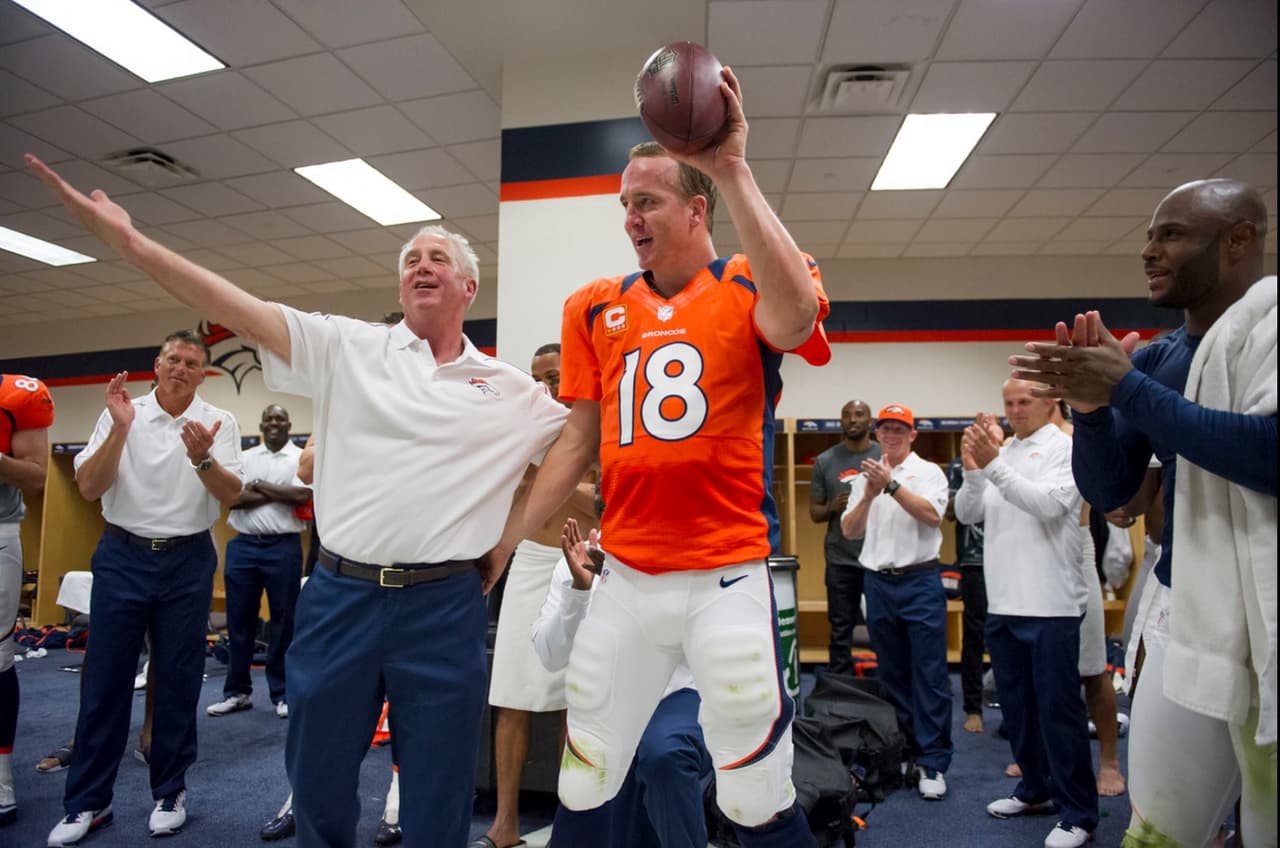 John Fox, en ese entonces HC de los Broncos, aplaudiendo la hazaña de Manning en el vestuario por sus pases de TD 400 y 401 de su carrera en 9 de septiembre del 2012.