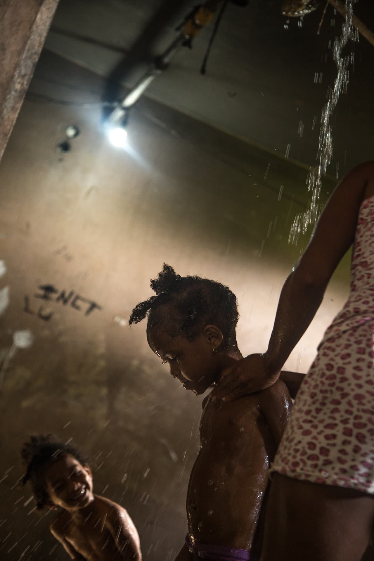 En Coco Solo se puede llegar a contar hasta nueve niños por cada adulto. La mayoría de los departamentos no cuentan con baño, por lo que sus residentes deben compartir una ducha improvisada. Esta queda en la casa de Luis Alberto Roger, de 32 años y padre de los dos niños que aparecen en la imagen.