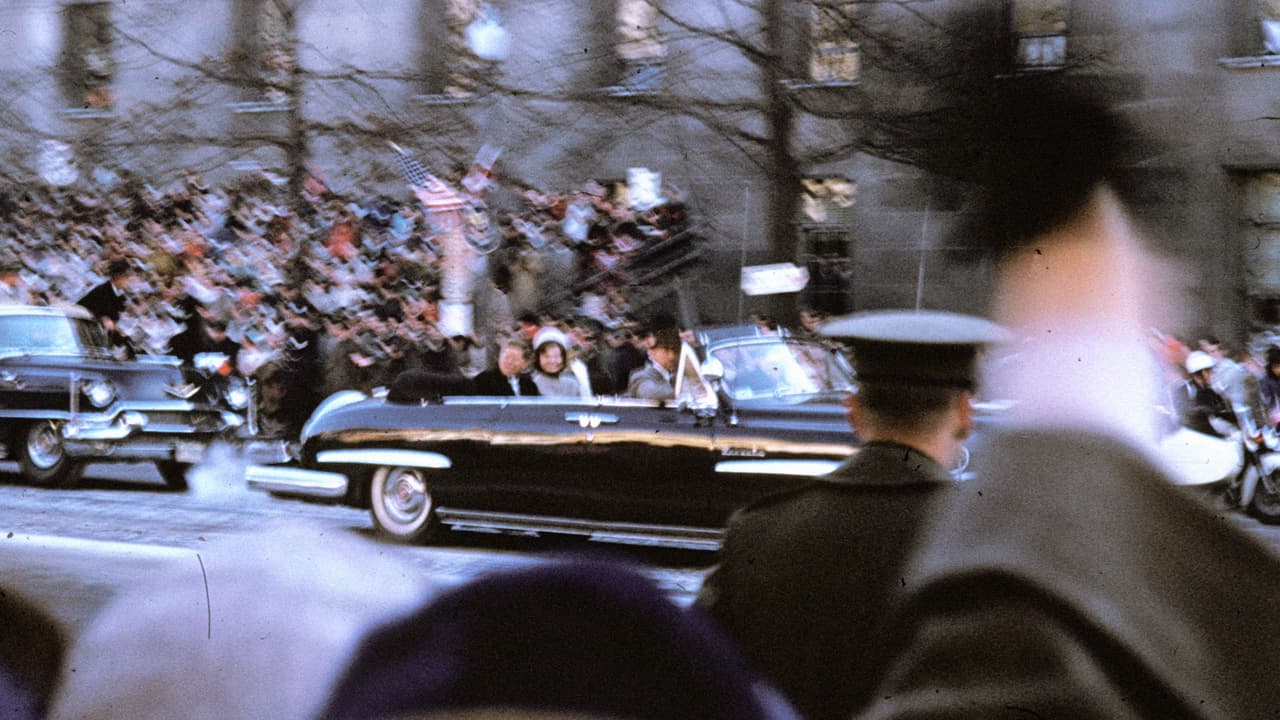 John Fitzgerald Kennedy y su esposa Jackie en la caravana presidencial de la Avenida Pensilvania, el 20 de enero de 1961. La pareja presidencial Kennedy pasea en la limusina Lincoln Cosmopolitan que en 1950 recibió Harry S. Truman. En 1961 recibió su propio vehículo, también Lincoln.