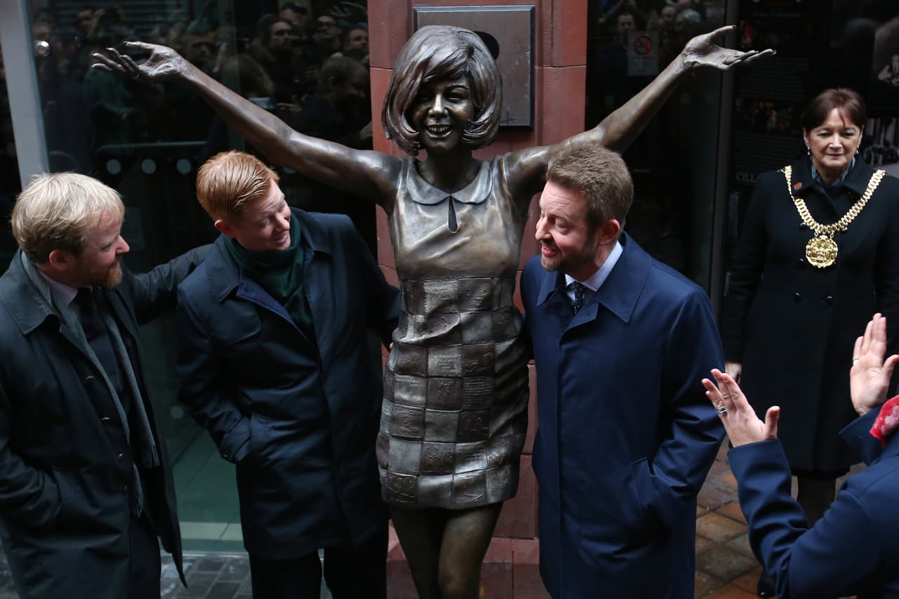 En el orden acostumbrado, Ben, Jack y Robert Willis, hijos de Cilla Black, junto a la estatua que desde este lunes está frente a The Cavern, honrando el legado de su madre, fallecida en 2015, en España.
