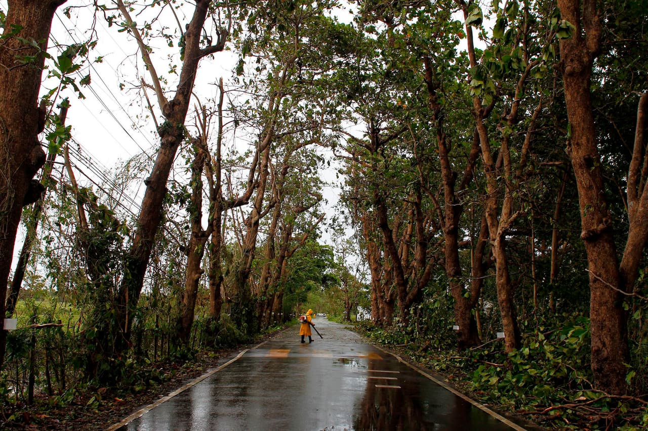 A worker removes debris from a road with a gas powered blower in the aftermath of Hurricane Irma in Rio Grande, Puerto Rico, on September 7, 2017. One of the most powerful Atlantic storms on record, the rare Category 5 hurricane churned westward off the northern coast of Puerto Rico early Thursday on a potential collision course with south Florida, where at-risk areas were evacuated. / AFP PHOTO / Ricardo ARDUENGO (Photo credit should read RICARDO ARDUENGO/AFP/Getty Images)