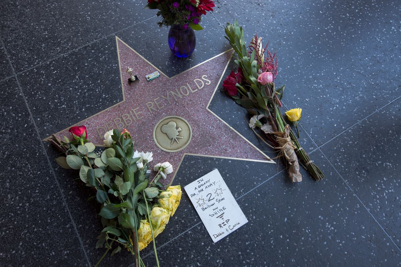 Flores y una estuilla plástica del premio Oscar en la estrella de Debbie Reynolds, quien falleció el miércoles, un día después de la muerte de su hija.