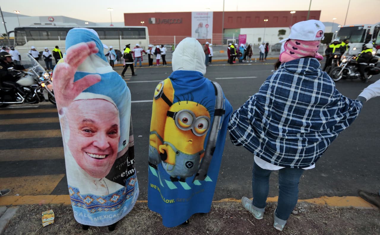 Este hombre carga una toalla con el rostro del papa Francisco sobre sus espaldas.