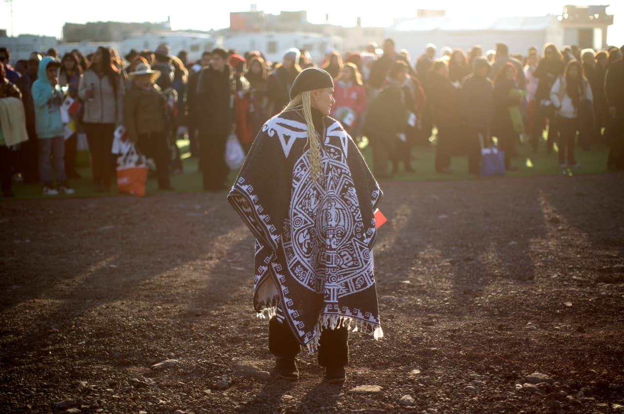 Esta mujer usa un jorongo con el impreso del Calendario Azteca.