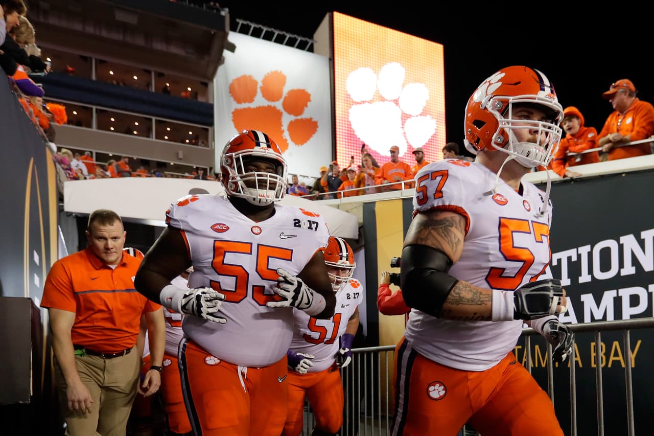 El guardia Tyrone Crowder # 55 y el liniero ofensivo Jay Guillermo # 57 de los Tigres de Clemson corren hacia el campo antes del partido del Campeonato Nacional 2017 ante Alabama.