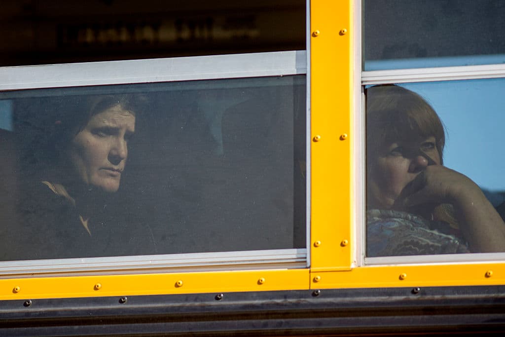 Sobrevivientes y testigos de la masacre son llevados en autobuses escolares a declarar ante las autoridades