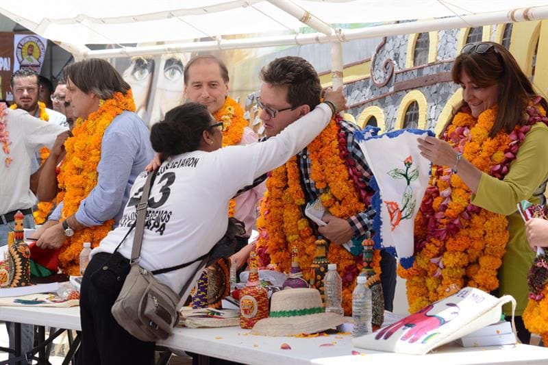 Familiares colocan guirnaldas de flores a los miembros del GIEI.