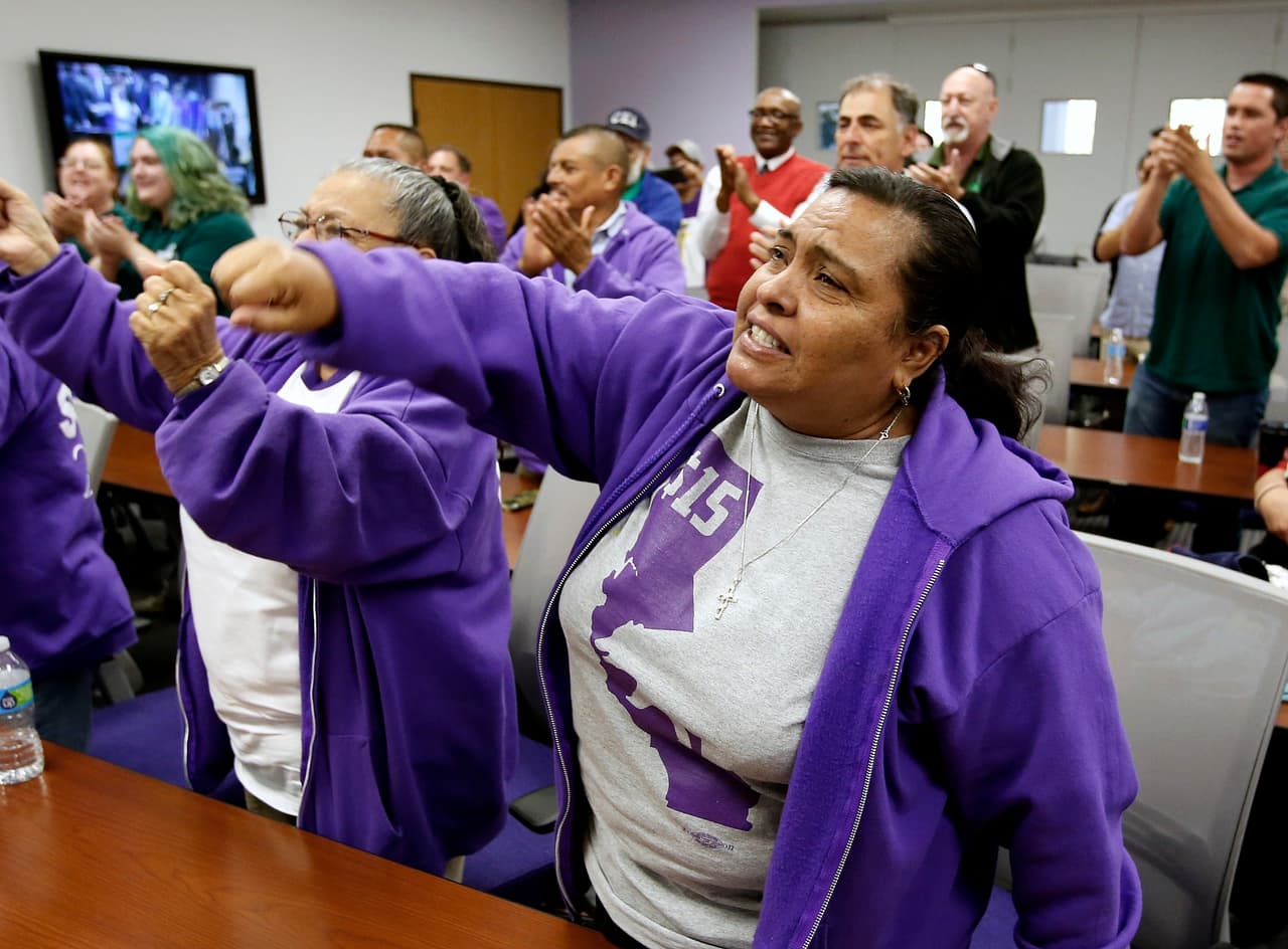 Patricia Ornelas, miembro del sindicato Employees International Union, levanta el puño para festejar el aumento del salario mínimo en California el 4 de abril. (AP Photo/Rich Pedroncelli)