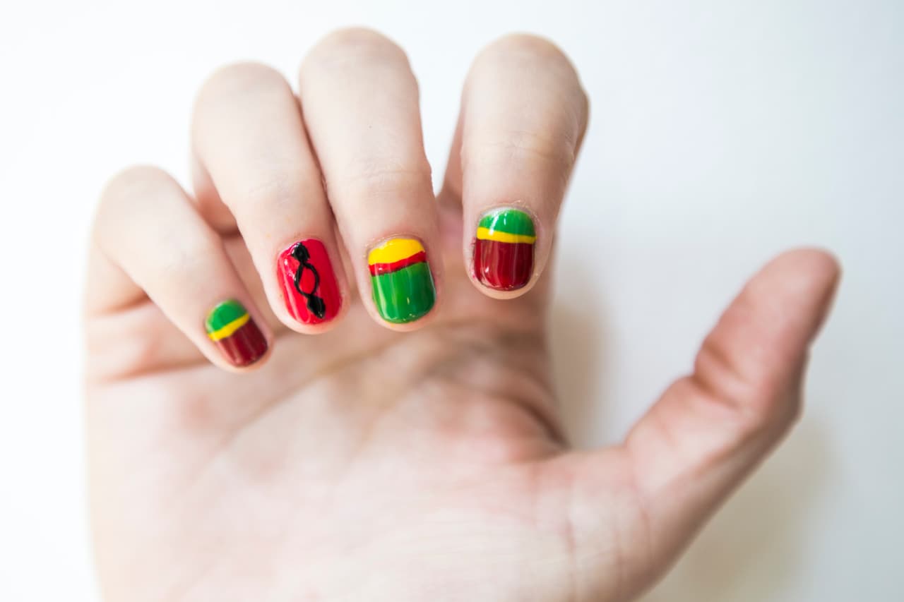 Bolivia: Aplica 2 capas de verde en la uña del meñique e índice y da 2 de color rojo en el anular y 2 en amarillo en la del dedo medio. Ya secas cubre con rojo 3/4 partes de las uñas de los dedos meñique e índice, después con un pincel delgado traza una línea amarilla horizontal entre los 2 colores. Repite lo mismo en la uña del medio pero con verde y rojo. Dibuja con un liner y tono negro en la uña del anular un óvalo y 2 rombos a cada lado.