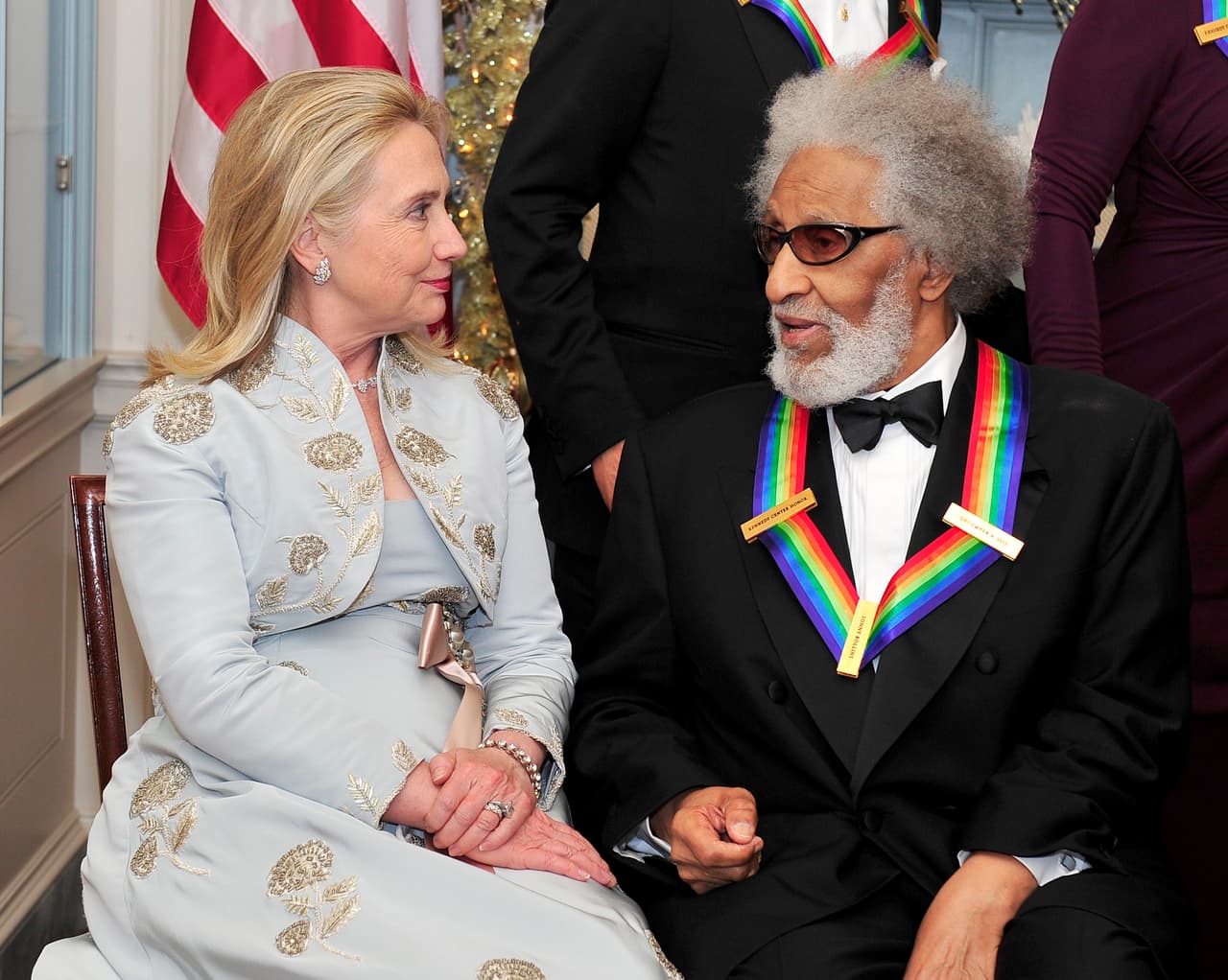 2011: El diseñador Oscar de la Renta, amigo de Hillary, en entrevista con Gotham Magazine comentó: “Le recomendé hace tiempo, (cuando era Secretaria de Estado) que se cortará el pelo. Pero me dijo que no podía hacerlo. Pues si visitaba una peluquería en otro país, el equipo de Seguridad Nacional tendría que verificar a la persona que le quisiera cortar el pelo”. Hasta 2012 la vimos usar en algunos eventos las ligas tipo scrunchie.