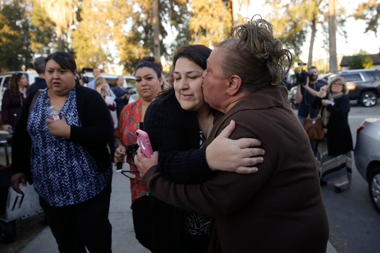 Una mujer besa y abraza a su hermana, una de las sobrevivientes del tiroteo