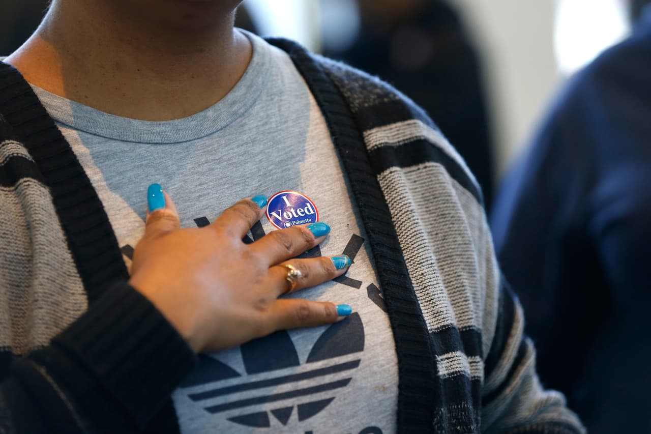 Esta mujer muestra el distintivo de que ya ha participado. (Foto por Gerald Herbert).