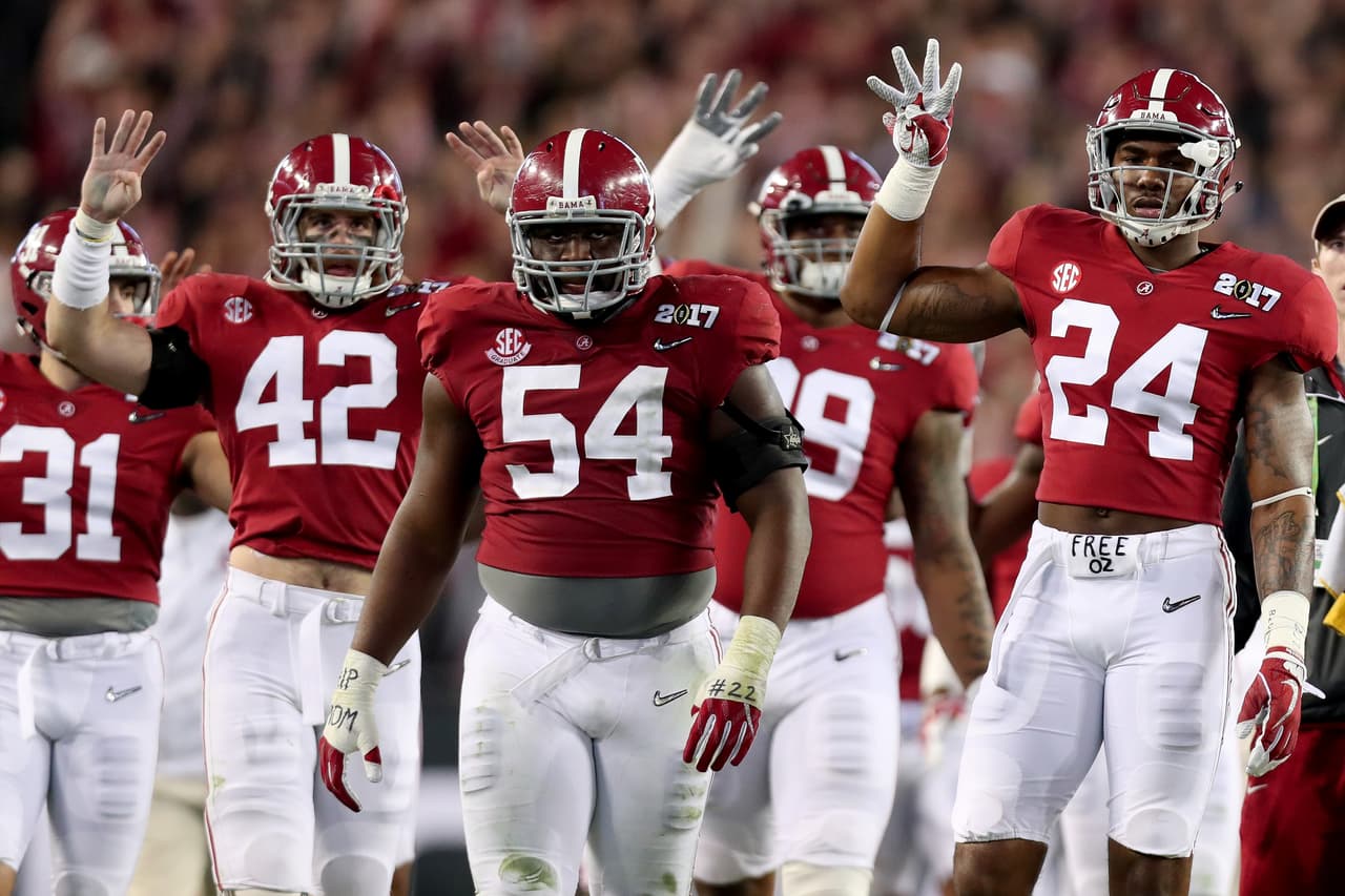 El linebacker Keith Holcombe # 42, el liniero defensivo Dalvin Tomlinson # 54, y el apoyador Terrell Hall # 24 del Alabama Crimson Tide reaccionan con burlas tras detener a Clemson con relativa facilidad en la primera mitad del encuentro.