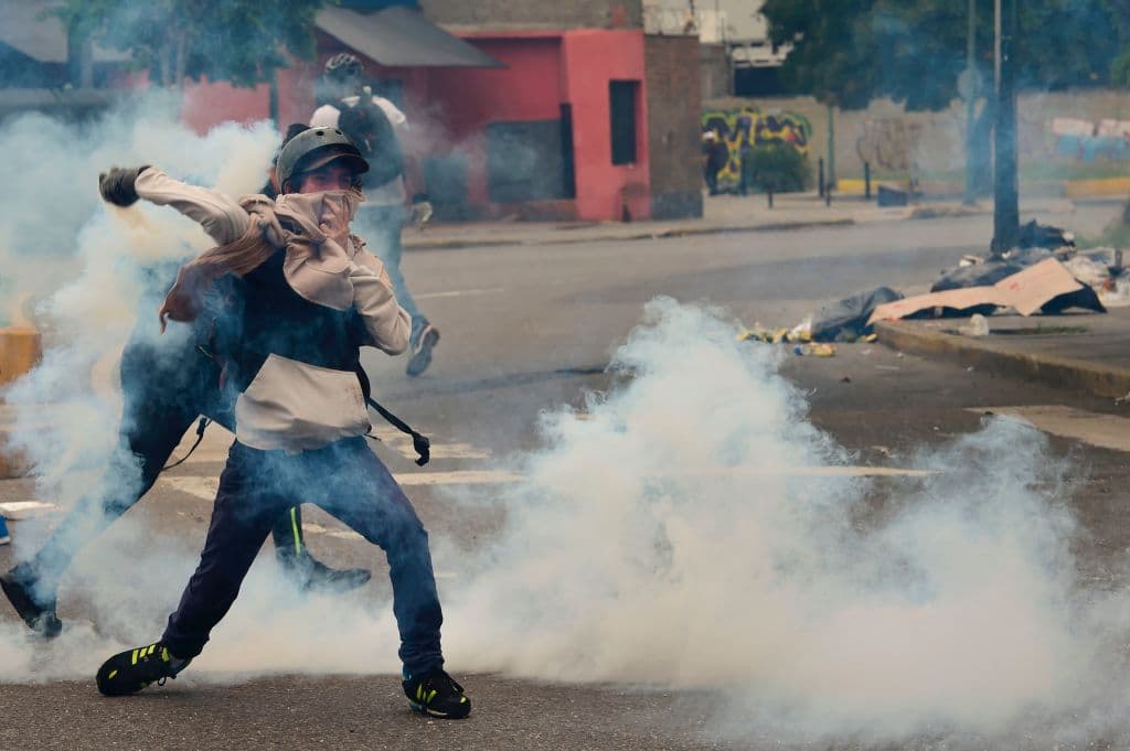 Mientras las autoridades lanzaban una batería de gases lacrimógenos, algunos opositores con sus caras cubiertas respondían devolviendo las bombas e incluso piedras y cocteles molotov. Muchos gritaban "libertad", pero también insultos contra los policías. Ronaldo Schemidt/AFP/Getty Images