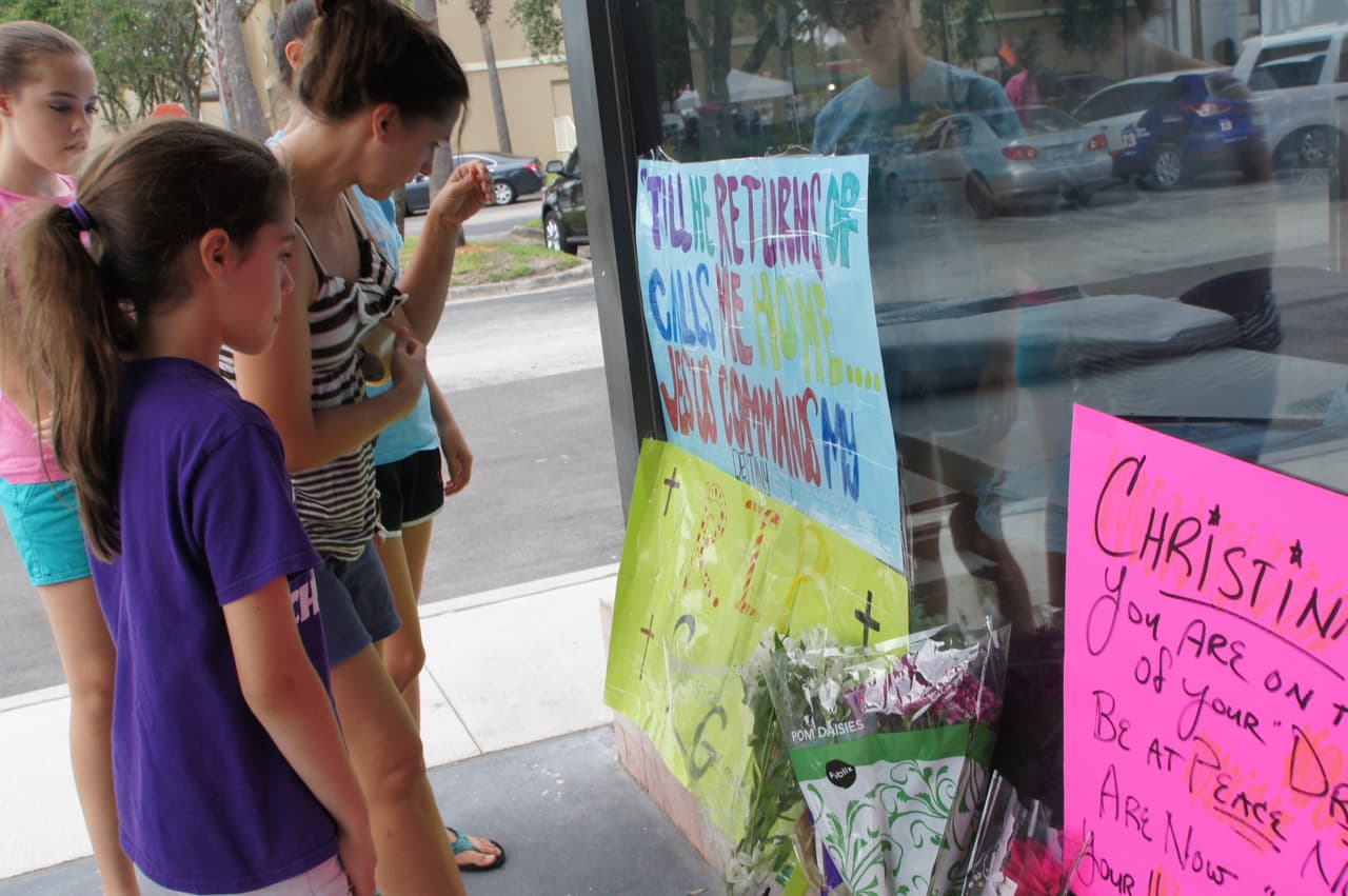 Varios niños y adolescentes se acercan a la entrada del teatro The Plaza Live para leer lo mensajes escritos