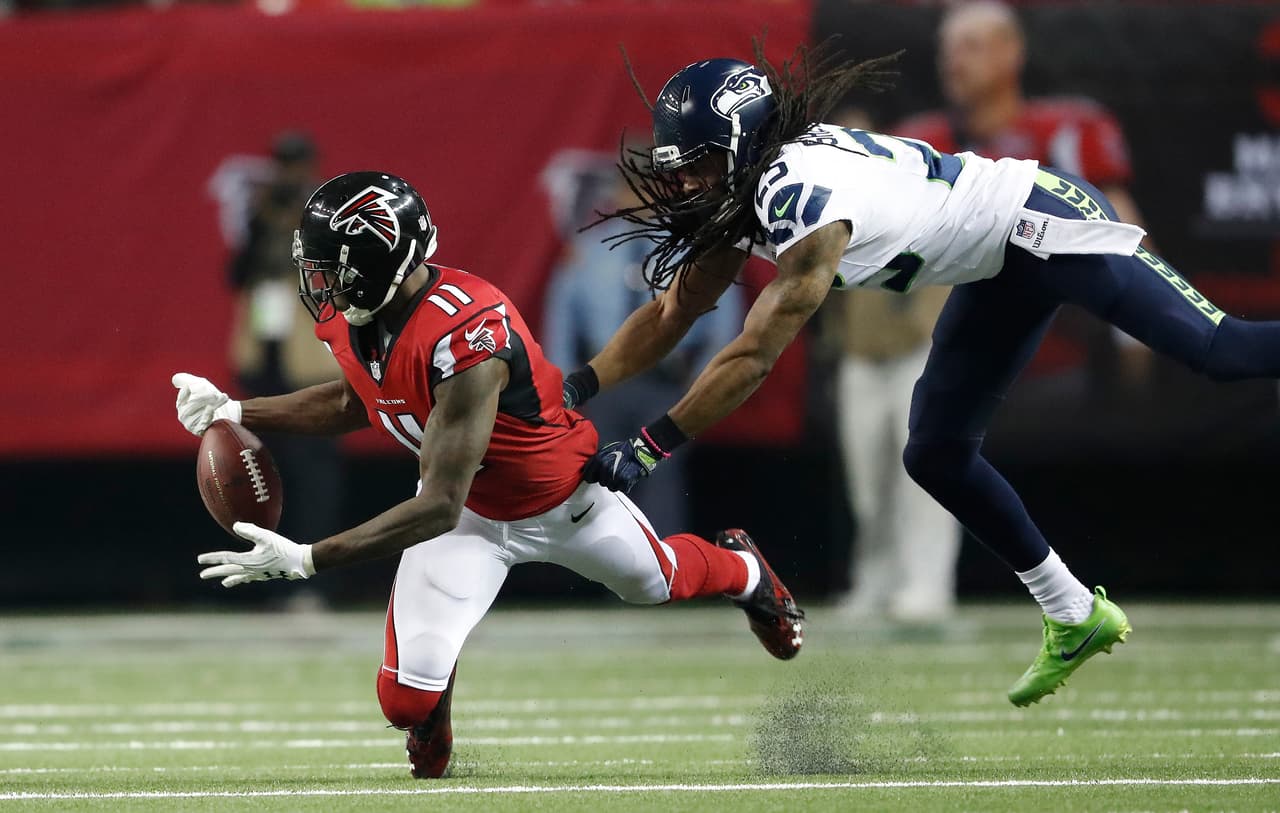 Atlanta Falcons wide receiver Julio Jones (11) misses the catch against Seattle Seahawks cornerback Richard Sherman (25) during the second half of an NFL football divisional football game, Saturday, Jan. 14, 2017, in Atlanta. (AP Photo/John Bazemore)